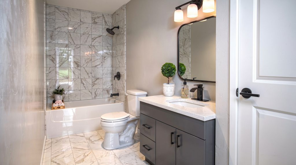 Forest Edge Place bathroom with marble-look vanity and stone accent wall